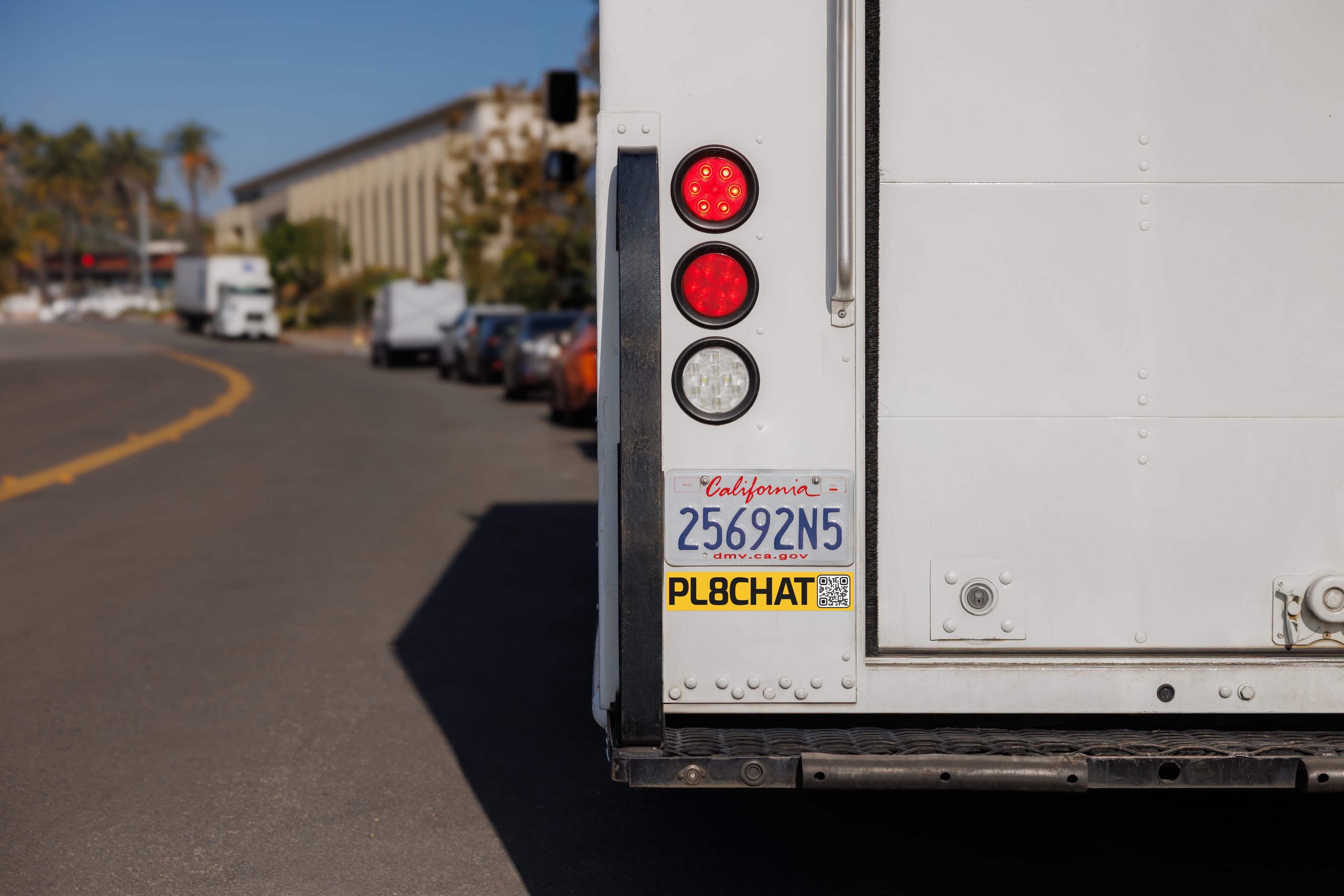 The rear of a PL8CHAT-connected fleet vehicle with illuminated lights.