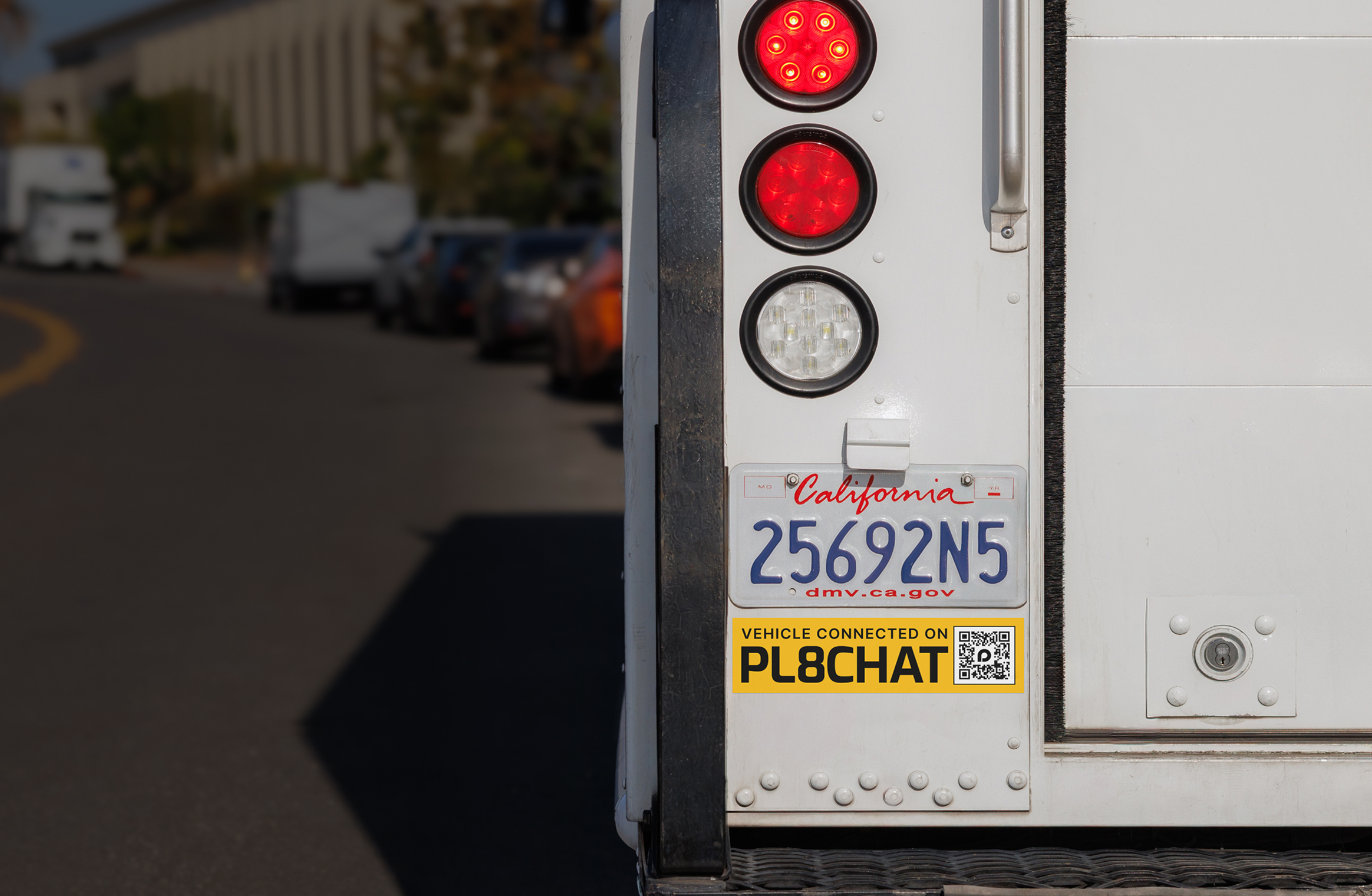 The rear of a vehicle with PL8CHAT branding and illuminated brake lights.